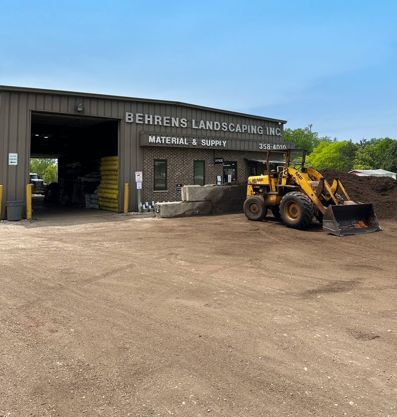 Behrens Landscape Material & Supply yard — front of building with loader and mulch pile